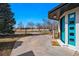 Bright blue front door, lush green trees and expansive driveway create a warm welcome at 1270 S Lowell Blvd, Denver, CO 80219