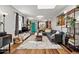 Open-concept living room featuring hardwood floors, modern décor, and a vibrant blue entry door at 1270 S Lowell Blvd, Denver, CO 80219