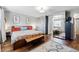 A spacious main bedroom with ample lighting and a bench at the foot of the bed at 1270 S Lowell Blvd, Denver, CO 80219