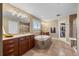 A full bathroom featuring double sinks, a soaking tub, walk-in shower, and a walk-in closet providing functional spaces at 1133 Lucky Ct, Castle Rock, CO 80109