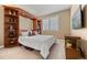 Cozy bedroom featuring a Murphy bed with built-in shelving, a side table, and a window at 1133 Lucky Ct, Castle Rock, CO 80109