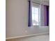 Bright bedroom with large window, violet curtains and light colored walls and carpet at 8018 Williams Fork Ave, Littleton, CO 80125