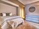 Comfortable bedroom featuring a patterned bedspread, decorative pillows, and a round mirror above a white dresser at 8018 Williams Fork Ave, Littleton, CO 80125