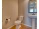 Well-maintained powder room with a pedestal sink, modern toilet, and fresh, clean finishes at 8018 Williams Fork Ave, Littleton, CO 80125