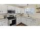 Bright kitchen features white cabinets, granite counters, stainless steel appliances, and modern fixtures at 20349 E Powers Pl, Centennial, CO 80015