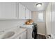 Efficient laundry room with white washer and dryer, storage cabinets, sink, and natural light at 20349 E Powers Pl, Centennial, CO 80015