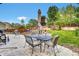 Outdoor patio with dining set in a fenced backyard with mature trees and grass at 11670 S Flower Mound Way, Parker, CO 80134
