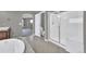 Bright primary bathroom featuring tiled floor, large tub, and glass shower stall at 11670 S Flower Mound Way, Parker, CO 80134