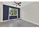 Bedroom with a navy accent wall, natural light, and a ceiling fan at 11670 S Flower Mound Way, Parker, CO 80134