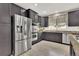 Modern kitchen featuring stainless steel appliances, dark cabinets, and granite countertops at 11670 S Flower Mound Way, Parker, CO 80134