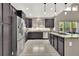 Modern kitchen with stainless steel appliances, dark cabinetry, and bright lighting at 11670 S Flower Mound Way, Parker, CO 80134