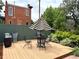 Inviting outdoor deck with modern patio furniture, lush greenery, and a striped umbrella at 2801 Champa St, Denver, CO 80205