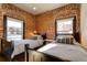 Charming bedroom featuring exposed brick walls, two windows, and two twin beds with stylish striped bedding at 2801 Champa St, Denver, CO 80205