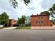 Exterior view of red brick building with white trim and a well-maintained front yard, perfect curb appeal at 2801 Champa St, Denver, CO 80205