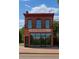 Exterior view of a charming brick building featuring large windows and a balcony, perfect for retail or office space at 2801 Champa St, Denver, CO 80205