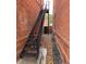Exterior metal staircase situated between brick walls, leading upwards to the back of the building at 2801 Champa St, Denver, CO 80205