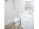 Bathroom with white vanity, toilet and tiled walk-in shower, and laminate wood floors at 9155 E Center Ave # 4B, Denver, CO 80247