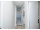 Hallway featuring light colored floors and walls leading to a bathroom and bedroom area at 9155 E Center Ave # 4B, Denver, CO 80247