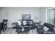 Comfortable living room showcases a black leather sofa with throw pillows, a modern rug, and minimalist decor at 9155 E Center Ave # 4B, Denver, CO 80247