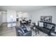 Bright open-concept living and dining area with black leather seating and a connecting kitchen with white cabinets at 9155 E Center Ave # 4B, Denver, CO 80247