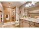 Bathroom showcasing a glass enclosed shower with tile surround, double vanity, and modern lighting at 14115 Blue Stem St, Broomfield, CO 80020