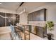 Modern bar area with sleek cabinets, stylish lighting, stainless steel appliances, and bar seating at 14115 Blue Stem St, Broomfield, CO 80020