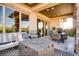 Covered patio area with stylish seating, a modern fire pit, and views of the surrounding landscape at 14115 Blue Stem St, Broomfield, CO 80020