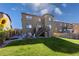 Expansive backyard featuring a patio, outdoor dining, a stone fireplace, steps to deck, and green lawn at 12841 Galapago St, Westminster, CO 80234