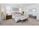 Spacious bedroom featuring neutral tones, a comfortable bed, and a view into a luxurious adjoining bathroom at 12841 Galapago St, Westminster, CO 80234