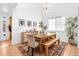 Bright dining room featuring a high ceiling, a wooden table with bench, and modern decor at 12841 Galapago St, Westminster, CO 80234