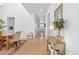 Light-filled hallway with wood floors, leading to dining area, with decoratively furnished console table at 12841 Galapago St, Westminster, CO 80234