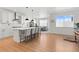 Open-concept kitchen with white cabinets, a central island with bar stools, and hardwood floors at 12841 Galapago St, Westminster, CO 80234