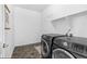 Modern laundry room with a front-load washer and dryer and shelving for storage, creating a functional space at 12841 Galapago St, Westminster, CO 80234
