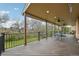 Spacious covered deck with wood flooring and black railings, perfect for outdoor dining and entertaining with ceiling fans at 8424 E Otero Cir, Centennial, CO 80112