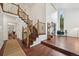 Grand foyer showcasing hardwood floors, a staircase with wrought iron accents, and soaring ceilings at 8424 E Otero Cir, Centennial, CO 80112