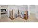 Upstairs hallway featuring wooden railings, access to bedrooms, and an overview of the living room at 8424 E Otero Cir, Centennial, CO 80112