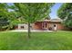 Expansive backyard with lush green grass, concrete patio, mature trees and a charming pergola at 18445 W 59Th Dr, Golden, CO 80403