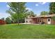 Large backyard with lush grass, mature trees, a concrete patio, and pergola at 18445 W 59Th Dr, Golden, CO 80403