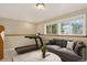 Finished basement area with a cozy seating area and a workout space by bright windows; virtually staged at 18445 W 59Th Dr, Golden, CO 80403