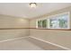 Neutral basement with carpet, a wood accent wall and two windows providing natural light at 18445 W 59Th Dr, Golden, CO 80403