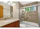Bathroom featuring tiled shower over tub, vanity, and a window at 18445 W 59Th Dr, Golden, CO 80403