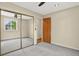 Spacious bedroom with neutral carpet, ceiling fan, and mirrored closet doors at 18445 W 59Th Dr, Golden, CO 80403