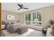 Bright bedroom with large windows offering ample natural light, carpet flooring, and a ceiling fan; virtually staged at 18445 W 59Th Dr, Golden, CO 80403