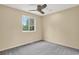 Bedroom with neutral walls, gray carpet, ceiling fan, and natural light from large windows at 18445 W 59Th Dr, Golden, CO 80403