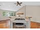 Open kitchen features stainless appliances, a gas cooktop, and seamless flow into the living room with a tiled fireplace at 18445 W 59Th Dr, Golden, CO 80403