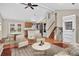 Open-concept living room with hardwood floors, a ceiling fan, and seamlessly connected to the kitchen; virtually staged at 18445 W 59Th Dr, Golden, CO 80403