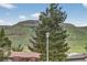 Breathtaking mountain view framed by mature trees, visible from this homes window at 18445 W 59Th Dr, Golden, CO 80403