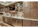 Modern basement wet bar featuring granite counters, mosaic backsplash, stainless appliances, and custom wood cabinets at 4810 Mountain Gold Run, Broomfield, CO 80023