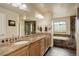 Luxurious bathroom with double vanity, tiled countertop, and separate tub and shower at 4810 Mountain Gold Run, Broomfield, CO 80023
