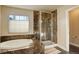 Elegant bathroom with soaking tub, stone tile surround and glass shower at 4810 Mountain Gold Run, Broomfield, CO 80023